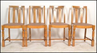 A set of four vintage 20th century Art Deco style oak dining chairs raised on block and turned