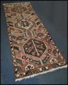 A 20th century Kelim woolen rug / runner , on red ground with a central medallion, inner border with