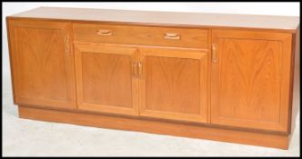 A 1970's G-Plan teak wood sideboard being raised on inset plinth base comprising a wide body above