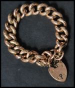 A hallmarked 9ct gold large heavy heart lock bracelet chain with engraved design. Weighs 39.5