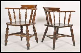 A pair of antique style Windsor - smokers bow armchairs being raised on turned legs united by