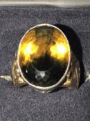 A 14ct gold diamond and citrine ring. The ring being set with a large bicolour oval citrine of green