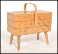 A vintage retro 20th century beechwood metamorphic sewing box raised on angular legs with opening