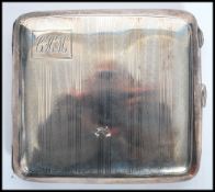 A silver hallmarked cigarette case with engine turned decoration, monogram cartouche to corner.