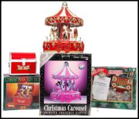 A group of three boxed Christmas toy displays to include a Classic Christmas Carousel animated