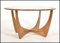 A 1970's G-plan teak model 8040 'Astro' coffee table, with inset circular glass top over stylized