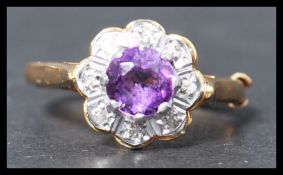 A hallmarked 18ct gold amethyst and diamond cluster ring set with a central round cut amethyst