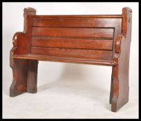 A 20th century antique style pine pew of small form with bench seat, panelled back rest and with