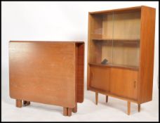 A 1970's retro G-Plan teak wood drop leaf dining table on shaped supports together with a teak