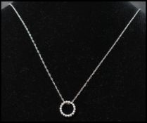 A 14ct gold and diamond pendant necklace strung with a diamond set halo on a white gold fancy link