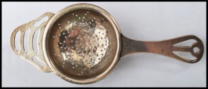 A silver hallmarked tea strainer bearing hallmarks for Birmingham. Weighs 26.6 grams. Measures 14 cm