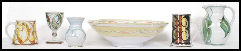 A collection of six pieces of studio pottery, each piece hand painted before glaze, all signed to