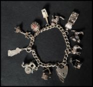 A hallmarked silver heart padlock clasp charm bracelet with many charms to include hedgehog cat