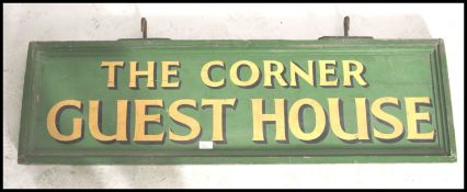 A retro mid century wooden painted advertising sign being double sided with green ground and