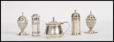 A collection of silver hallmarked table cruets, to include blue glass lined salt and pepper