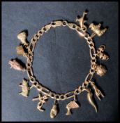 A hallmarked 9ct gold charm figaro link bracelet chain having a lobster claw clasp. Charms to