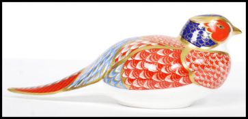 A Royal Crown Derby Pheasant paperweight, with red stamp to underside,  silver stopper, 18cm long