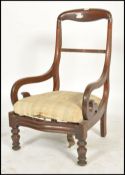 A 19th century Regency mahogany armchair. Raised on turned legs with loose cushion seat. Flanked