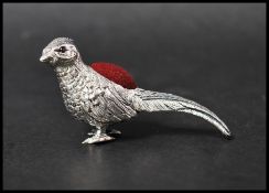 A 925 silver Victorian style pincushion in the form of a pheasant with red velvet cushion. Marked