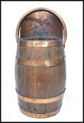 A 19th century coal bin scuttle in the form of a coopered barrel having brass and copper mounts.