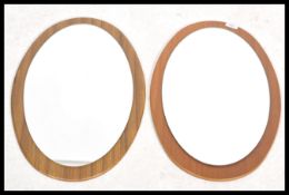 A pair of retro 20th century teak wood frameless mirrors, teak wood shaped surrounds with central