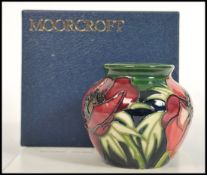 A Moorcroft ceramic vase tube lined decorated with flowers in the Anemone Tributte pattern