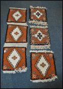 A group of five 20th century Kelim woolen rug panels, each on cream ground with a central medallion,