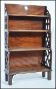 A 19th century Georgian solid mahogany ecclesiastical four tier waterfall bookcase having fretted