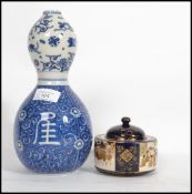An Oriental Chinese ceramic double gourd vase of traditional blue and white form along with a