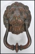 An early 20th century cast iron lion mask door knocker with remnants of original paint. Measures