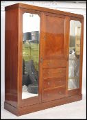 An Edwardian mahogany inlaid triple wardrobe compa