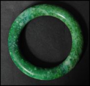 An Oriental carved Chinese jade bangle of circular form. The bangle of deep green colour.