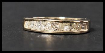 A 14ct gold and diamond half eternity ring set with 9 cushion cut diamonds in a channel setting.
