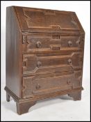 A 1920's Jacobean oak bureau desk raised on bracket legs with geometric panelled drawers under