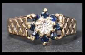 A hallmarked 9ct gold sapphire and diamond ring having a central illusion set diamond surrounded