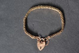 A 9ct gold heart padlock clasp bracelet chain. With safety chain. The clasp stamped 9ct. Tests as