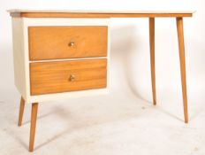 A retro mid century students bureau desk being raised on tapering legs of beech wood supporting a