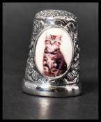 A 925 silver thimble with an enamel painted plaque depicting a cat. Marked 925. Weight 12.5g.