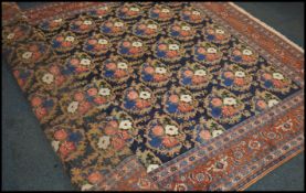 A good large 20th century wool and silk rug / carpet, on red ground with a central floral panel,