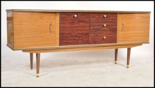 A 1950's retro laquered sideboard being raised on tapering legs with a series of drawers and