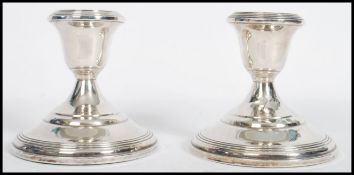 A pair of silver sterling candlesticks by Fisher. Each with circular bases and single sconces marked