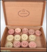 A 19th century ivory drafts set comprising stained