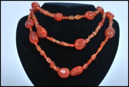 A vintage orange agate stone bead necklace of varied graduating form. Measures 64cm long.
