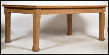 A large early 20th century solid oak Air MInistry type school library table being raised on square