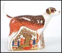 A Royal Crown Derby paperweight of a dog, Foxhound, with gold stopper, red stamp to base, dated to