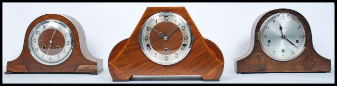 A group of three vintage 20th century wooden cased mantle clocks to include a walnut cased inlaid
