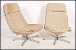 A pair of contemporary swivel lounge armchairs, raised on chrome supports surmounted by