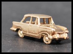 A hallmarked 9ct gold miniature model of a Triumph Herald with working wheels. Weighs 5 grams.