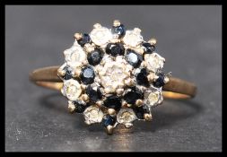 A hallmarked 9ct sapphire and diamond cluster ring having illusion set diamonds with round cut