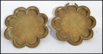 A pair of 19th century Islamic brass wall chargers. The scalloped edges with decoration of deities